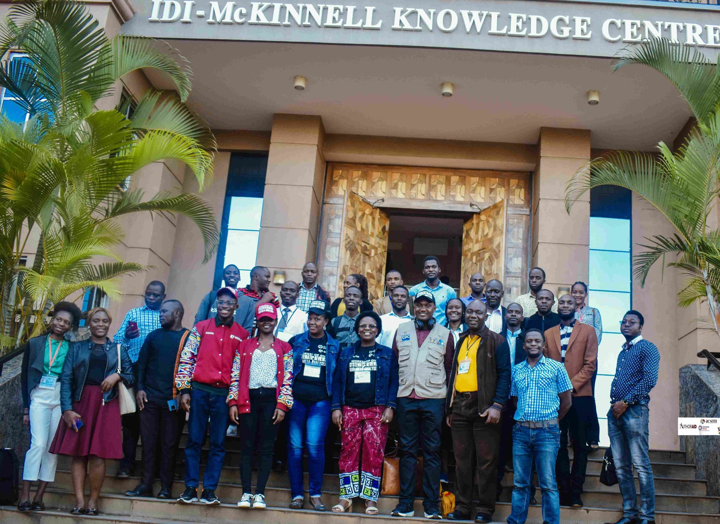 Participants of an SRN systematic review and meta-analysis workshop gathered on the steps of the IDI-McKinnell Knowledge Centre.